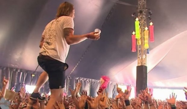 Рок-музыкант поймал бокал пива, стоя на руках у фанатов