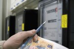 Людина з платіжками і грошима в руках
