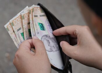 Людина, яка тримає гаманець із грошима