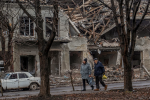 Люди на тлі зруйнованого міста / фото: CNN