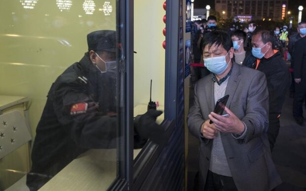 Жителі Уханя проходять паспортний контроль на вокзалі. Фото: Сіньхуа