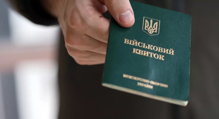 Человек, держащий военный билет в руке