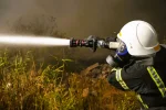 Рятувальник гасить пожежу на полях зрошення в Одесі