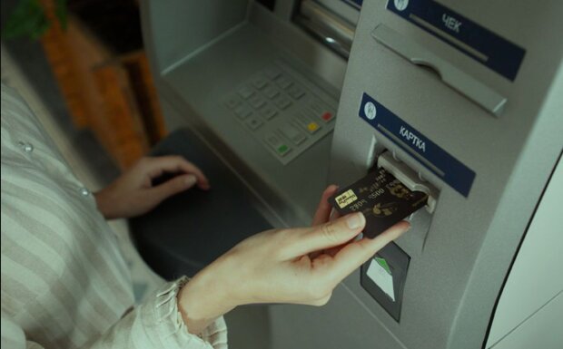 Человек, снимающий деньги с банкомата