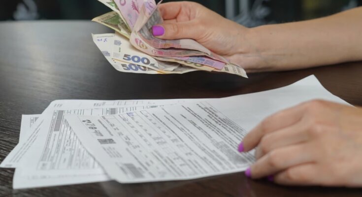 Женщина оплачивает коммуналку