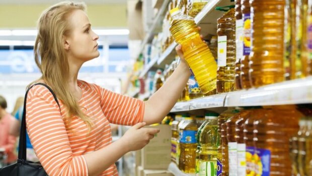 Жінка купує соняшникову олію