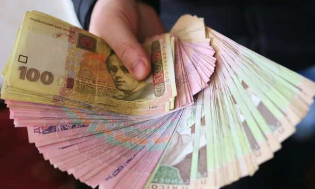 Деньги в руках пенсионера — новые выплаты до 5300 гривен
