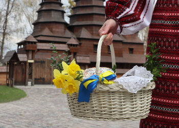 Женщина с пасхальной корзиной возле храма