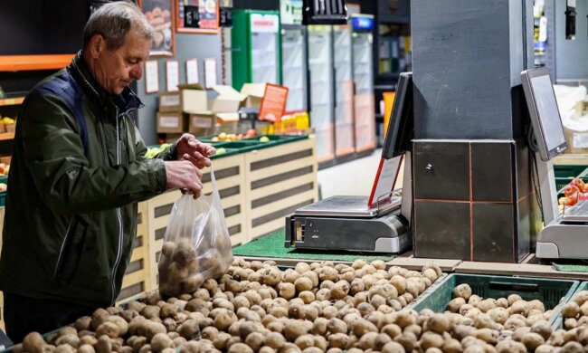 Чоловік, який вибирає картоплю в магазині