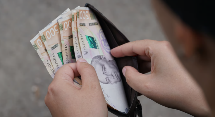 Человек, держащий кошелек с деньгами