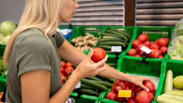 Женщина, покупающая помидоры