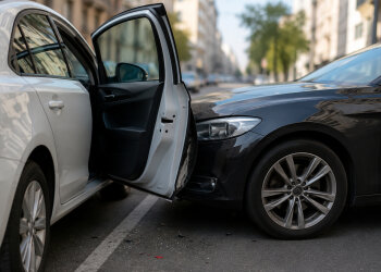 Відчинені двері авто на дорозі