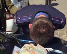 Спіймали за руку: коп "віджав" солідну суму в зоні АТО