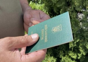 Человек, держащий в руках военный билет