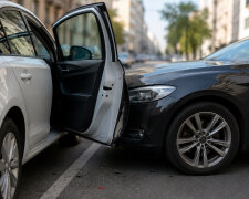 Відчинені двері авто на дорозі