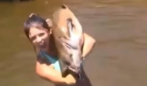 Дівчина спіймала гігантську рибу голою рукою