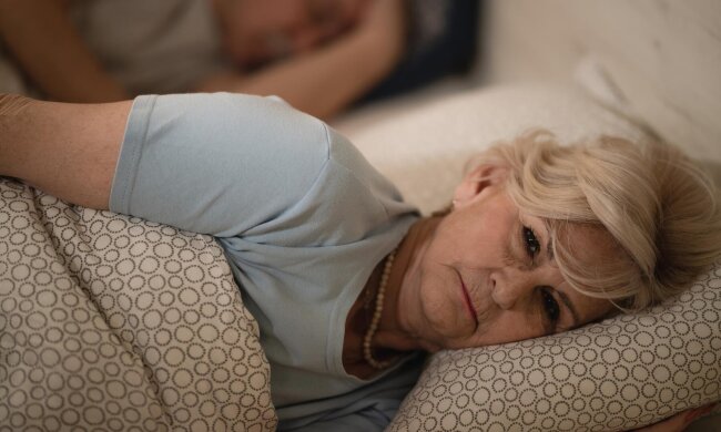 Жінка лежить у ліжку / фото: Freepik