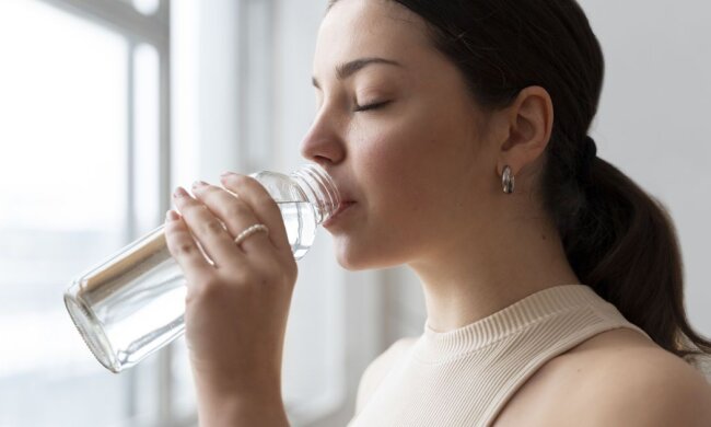 Дівчина п'є воду