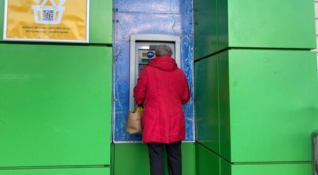 Людина біля банкомату, фото: Знай.ua