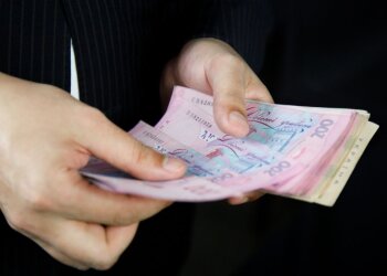 Людина, яка тримає гроші