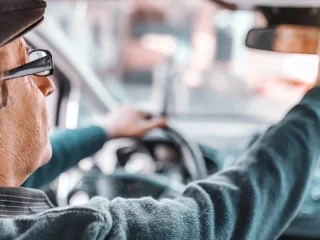 Літній водій за кермом автомобіля