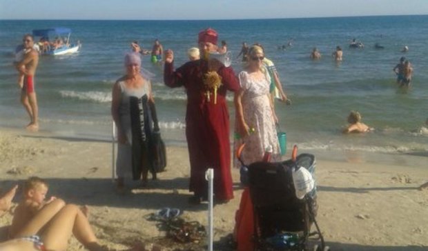 На пляже Херсонщины батюшка дарит иконки ование 