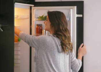 Женщина, которая лезет в холодильник