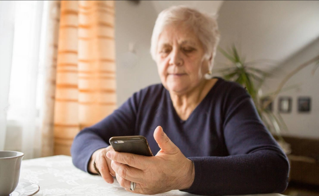 Пенсіонерка з телефоном в руках
