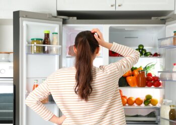 Жінка, яка стоїть біля холодильнику